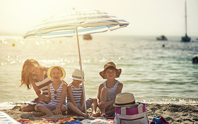 Familie am Strand mit Sonnenschutz